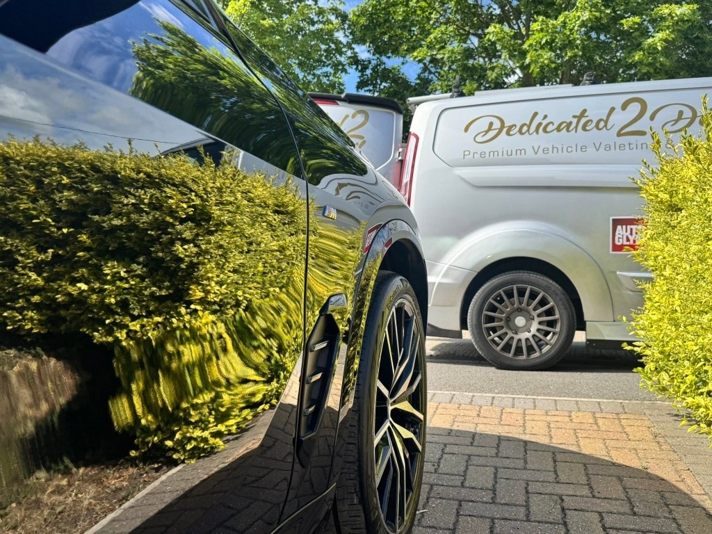 Dedicated 2 Detail van beside a freshly detailed black car